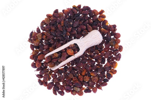 Dried sea buckthorn berries in wooden spoon isolated on white
