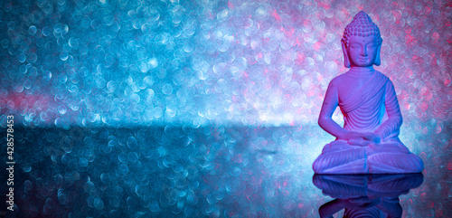 Canvas Print illuminated stone Buddha statue on acrylic underground in front of an illuminate