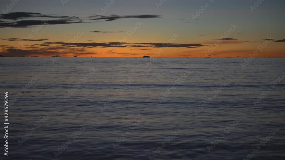sunset or sunrise on sea and ocean wave with golden sky or red and orange sunlight on twilight with fishing boat on water and cloud for landscape scene and nature night scenic or morning background 4K sunset or sunrise on sea and ocean wave with golden sky or red and orange sunlight on twilight with fishing boat on water and cloud for landscape scene and nature night scenic or morning background 4K