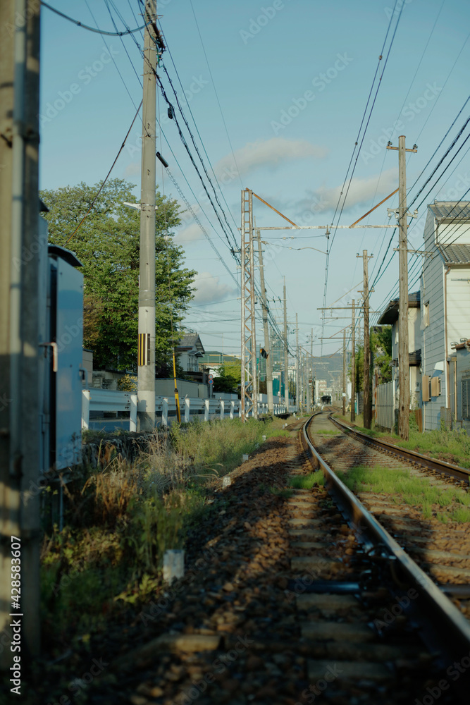 Vertical photo of railway tracks in the morning. Electrical wire and cables. Local tram train tracks in Kyoto, Japan. Vertical photo of railway tracks in the morning. Electrical wire and cables. Local tram train tracks in Kyoto, Japan.