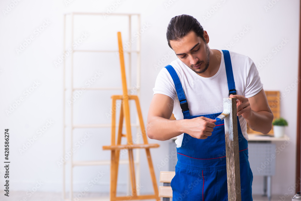 Young male contractor working in workshop