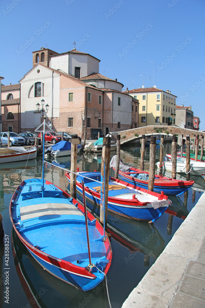 three blue wooden boats  in the canal Chioggia, Italy