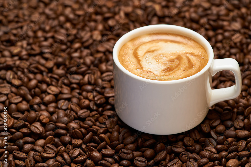Cup of espresso coffee on Background made of roasted brown coffee beans Cup of espresso coffee on Background made of roasted brown coffee beans