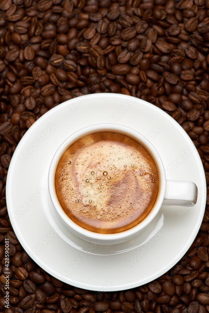 Cup of espresso coffee on Background made of roasted brown coffee beans Cup of espresso coffee on Background made of roasted brown coffee beans