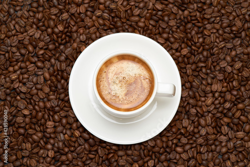 Cup of espresso coffee on Background made of roasted brown coffee beans