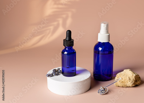 Cosmetic packaging set with lavender on beige background with tropical leaf shadow. herbal alternative medicine. Beauty skincare concept template. copy space
