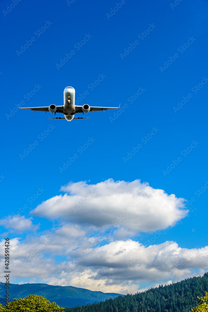 Obraz premium flight of the airplane (jet) over beautiful blue sky with white clouds