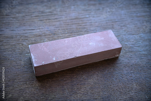 A bar for sharpening blades, a water stone on a wooden table
