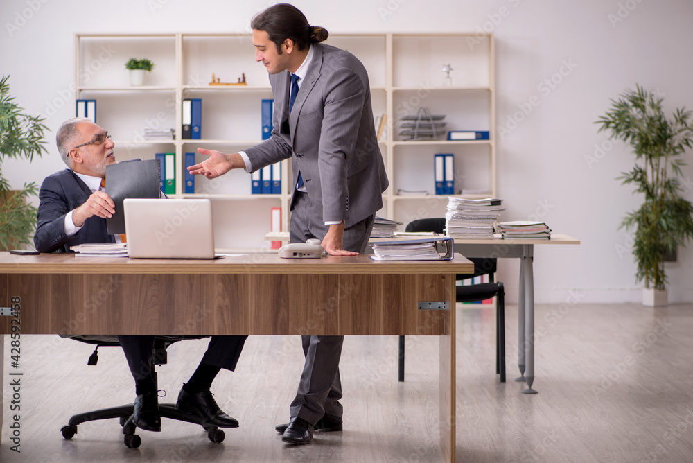 Two employees sitting at workplace Two employees sitting at workplace