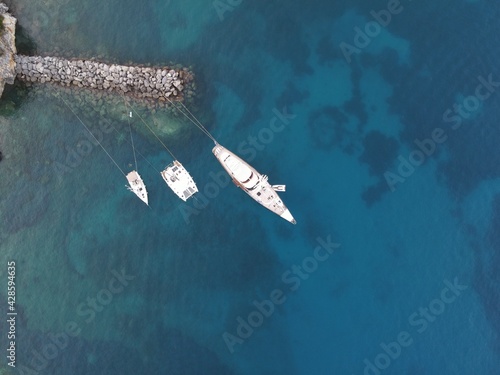 Aerial View Of Catamaran And A Yacht Docked In Marina Of Valtos Tropical Beach In Parga, Tourist Destination In Greece