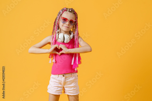 Trendy DJ girl in bright clothes, headphones and bright dreadloc