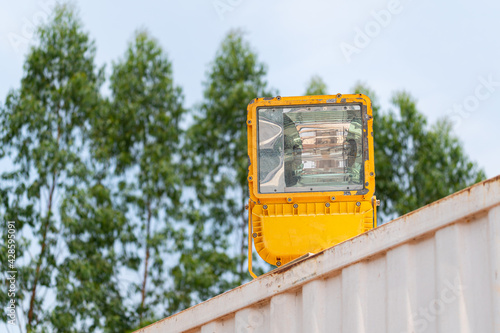 A powerful heavy  industry use LED spotlight which is installed on container roof 's part at warehouse storage in logistic factory area. Close-up and selective focus. Industrial equipment object. photo