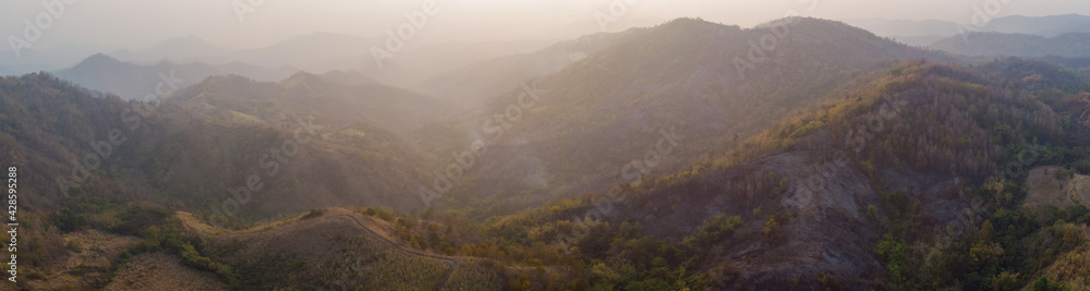 Beautiful yellow mountain landscape with fog and forest. sunrise in mountains, Wildfire in the mountains.