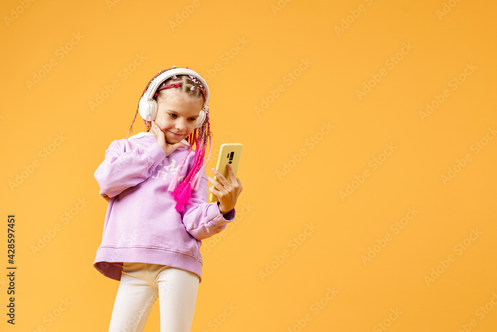Pretty modern girl with pink dreadlocks in headphones smiling an Pretty modern girl with pink dreadlocks in headphones smiling an