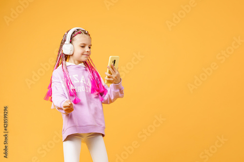 Fotografija Pretty modern girl with pink dreadlocks in headphones smiling an