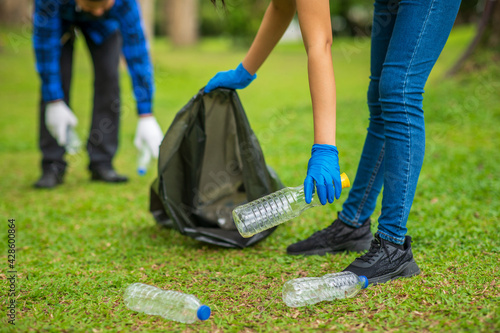 Save the world concept,volunteers carry water bottles,plastic bags that have fallen in the park put them in trash,Environmental protection,volunteering for charity,Waste disposal through recycling.