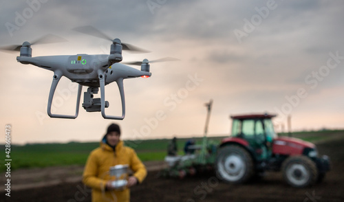 Drone flying above tractor in field