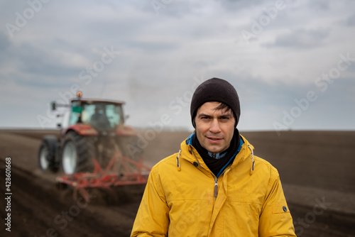 Farmer standing in front of tractor in field © Budimir Jevtic