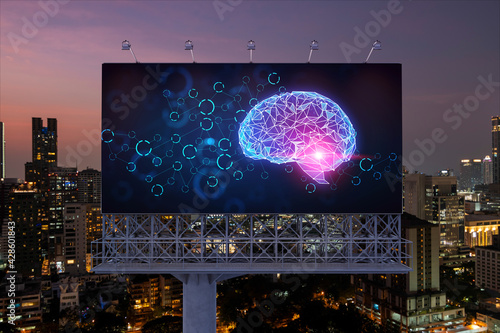 Brain hologram on billboard with Bangkok cityscape background at night time. Street advertising poster. Front view. The largest science hub in Southeast Asia. Coding and high-tech science.