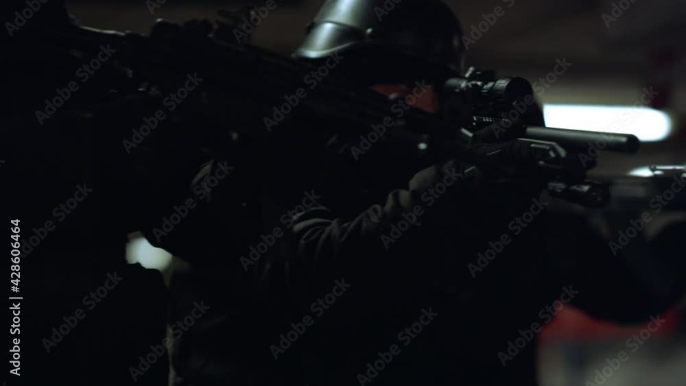 Special ops police team exploring parking. SWAT officers aiming rifles Special ops police team exploring parking. SWAT officers aiming rifles