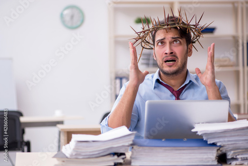 Young male employee wearing prickly wreath on head