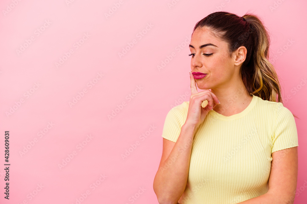 Fototapeta premium Young caucasian woman isolated on pink background
