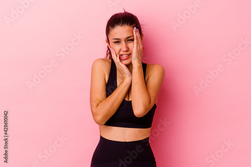 Young sport Indian woman isolated on pink background whining and crying disconsolately.