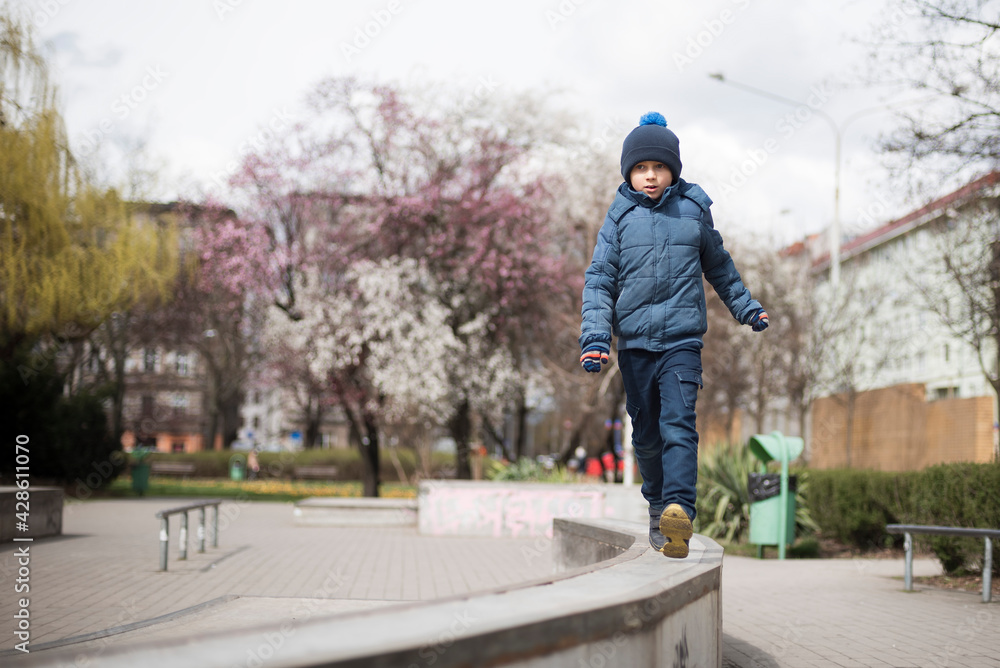 Young boy exercies in the parkour  during sunny spring day