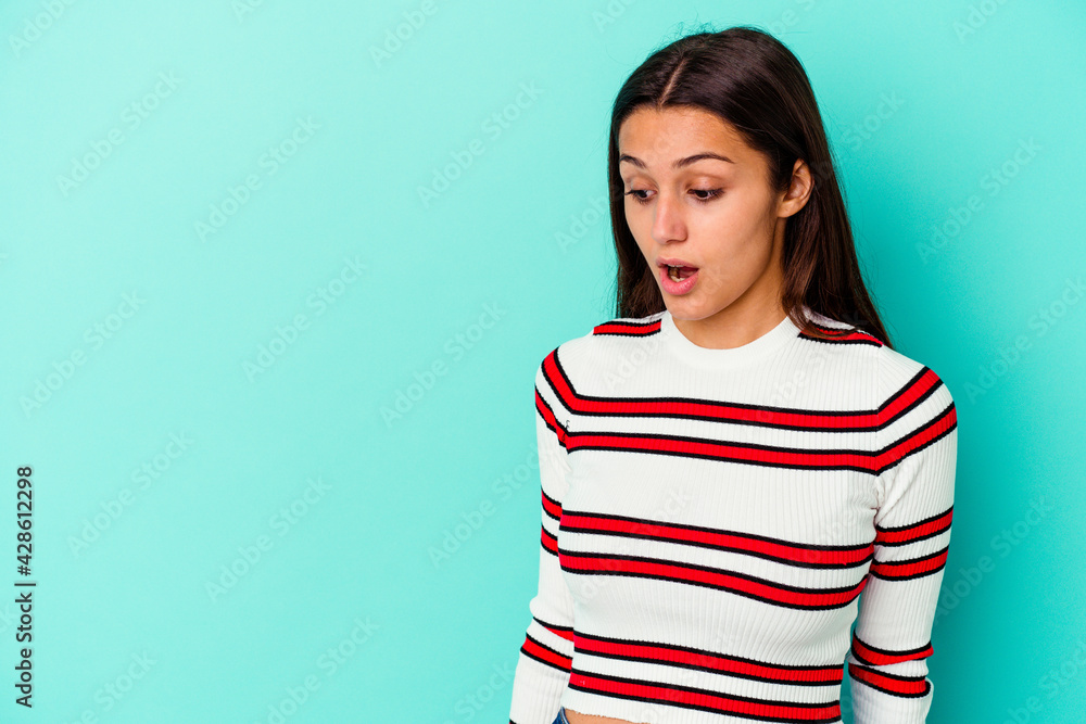 Young Indian woman isolated on blue background being shocked because of something she has seen. Young Indian woman isolated on blue background being shocked because of something she has seen.