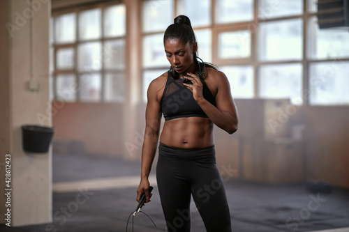 Fotografia Woman standing with a skipping rope at the gym