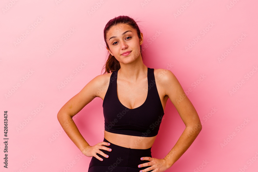 Young sport Indian woman isolated on pink background confident keeping hands on hips. Young sport Indian woman isolated on pink background confident keeping hands on hips.