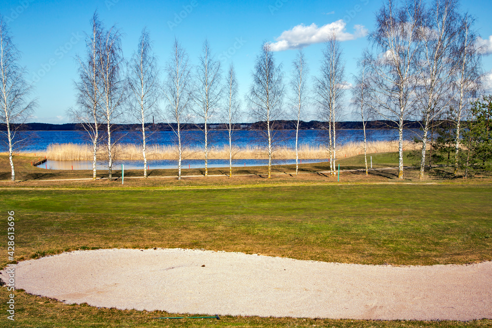 Obraz premium Golf place with gorgeous green and nice Kisezers lake view in Riga, Latvia 
