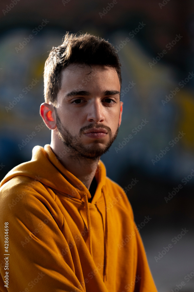 Fototapeta premium chico joven mirando a camara con actitud seria, en lugar oscuro