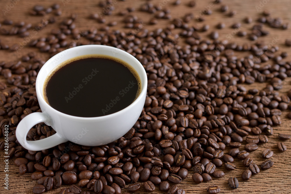 Black coffee and coffee beans roasted on wooden background,copy space. Black coffee and coffee beans roasted on wooden background,copy space.