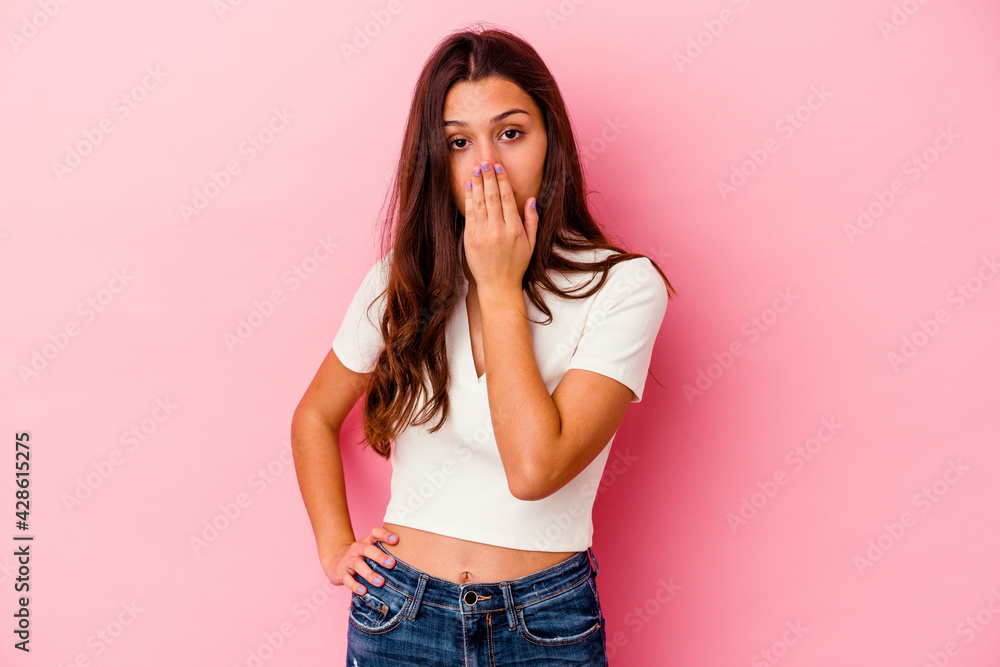 Young Indian woman isolated on pink background shocked, covering mouth with hands, anxious to discover something new. Young Indian woman isolated on pink background shocked, covering mouth with hands, anxious to discover something new.