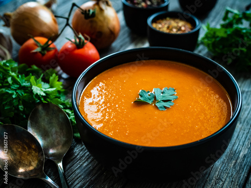 Fotografie Cream tomato soup on wooden table