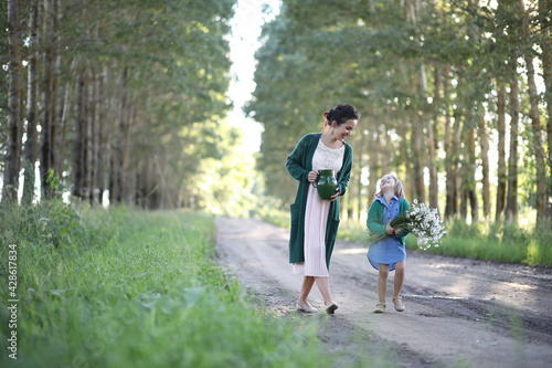Fototapeta Naklejka Na Ścianę i Meble -  Mother with daughter walking on a road