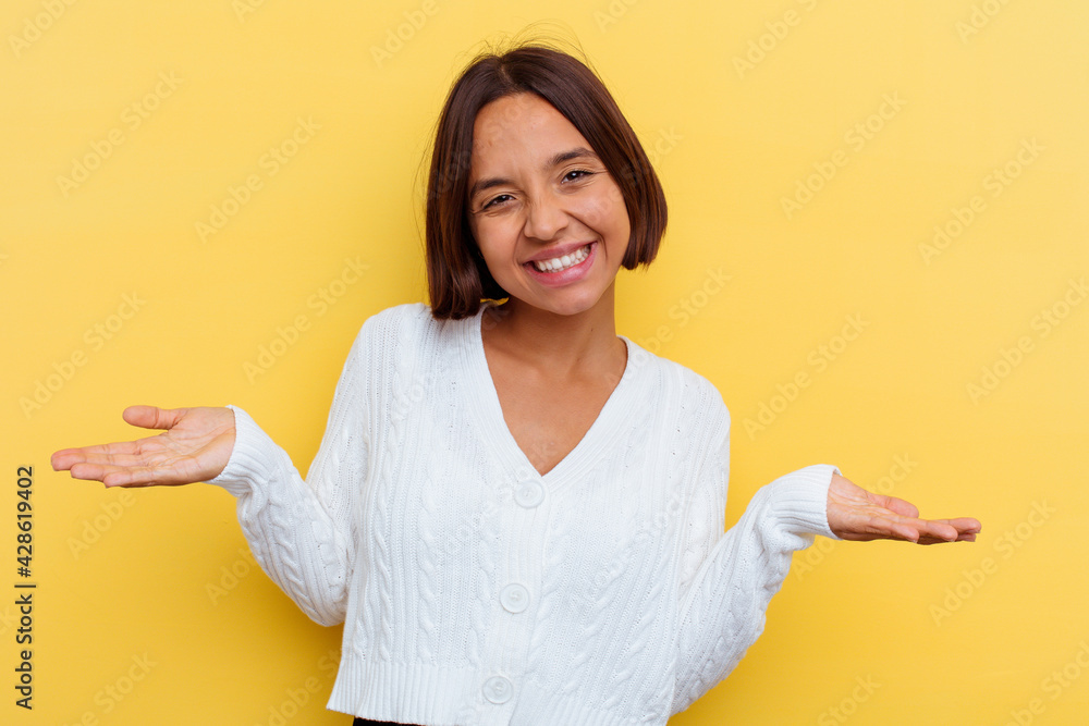 Young mixed race woman isolated on yellow background showing a welcome expression. Young mixed race woman isolated on yellow background showing a welcome expression.