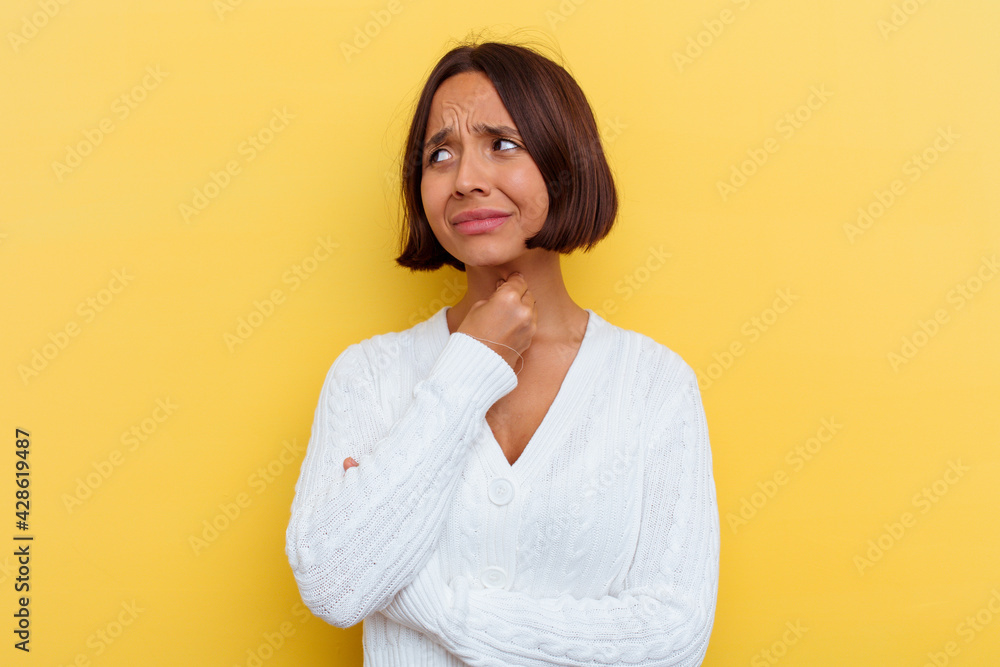 Fototapeta premium Young mixed race woman isolated on yellow background suffers pain in throat due a virus or infection.