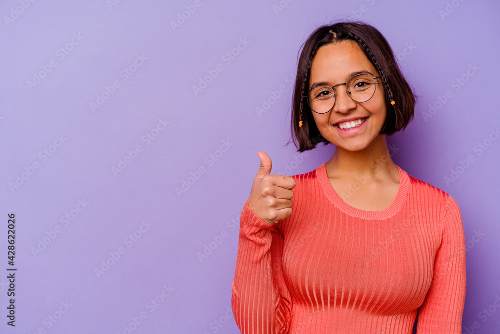 Young mixed race woman isolated on purple background smiling and raising thumb up Young mixed race woman isolated on purple background smiling and raising thumb up