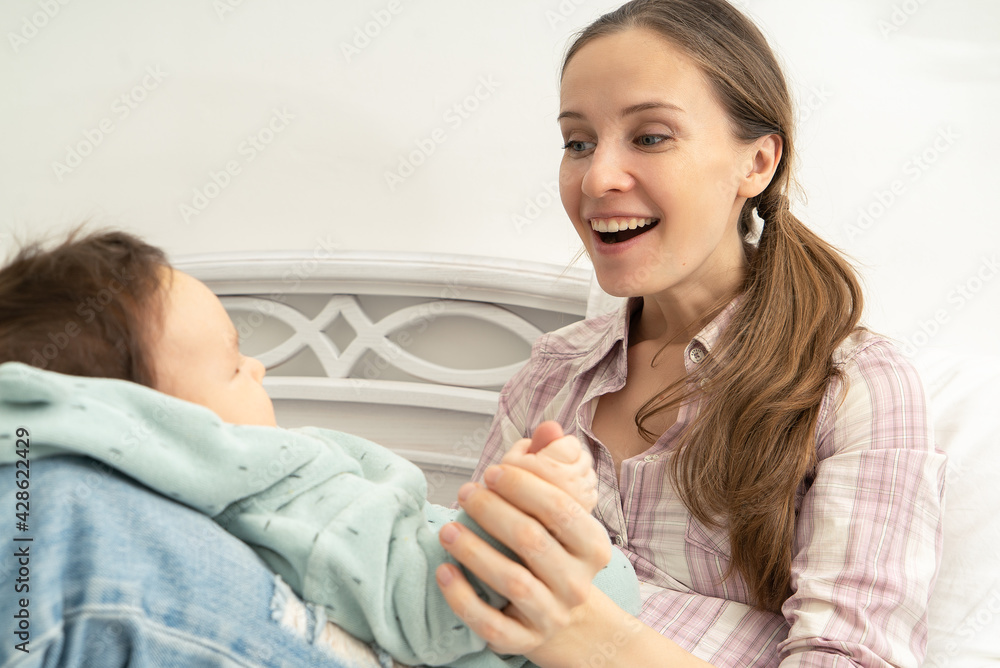 Portrait of a joyful young mother playing with a small child Portrait of a joyful young mother playing with a small child