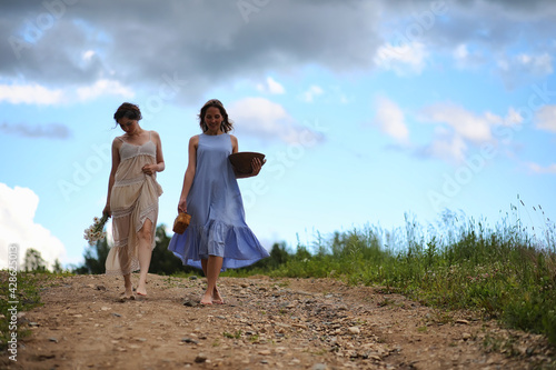 Two girls in dresses in summer field