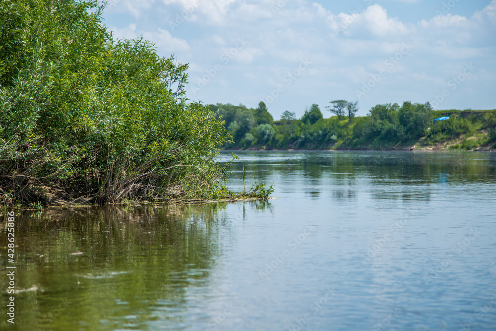 View of the Oka river from the shore, the opposite Bank is visible . The sky is reflected in the water