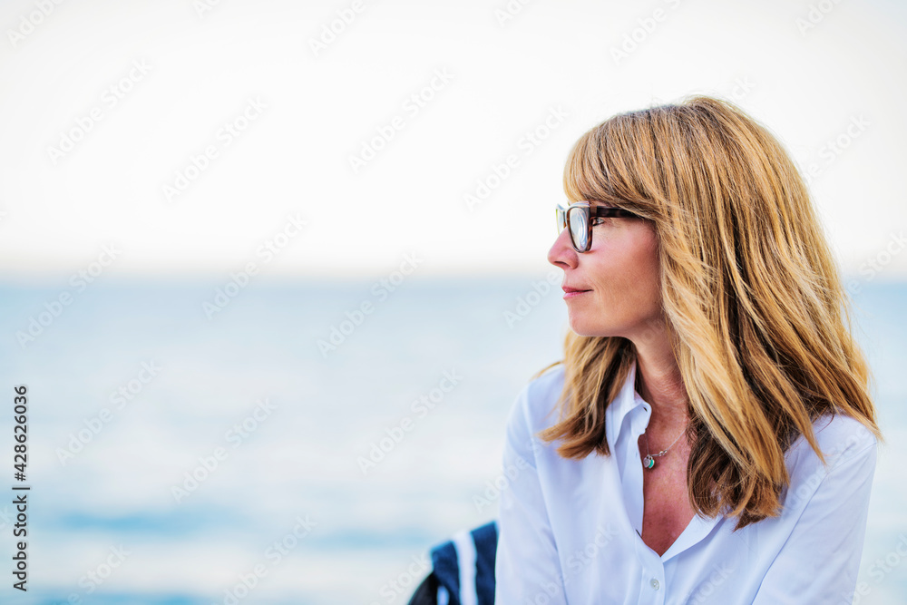 Profile portait of middle aged woman relaxing by the sea Profile portait of middle aged woman relaxing by the sea