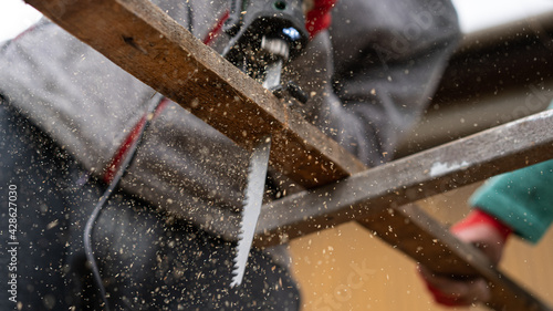 a worker saws wooden slats with a sawing machine