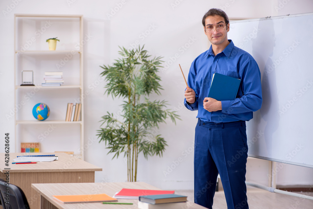 Young male teacher in front of white board Young male teacher in front of white board