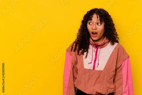 Young mixed race woman isolated on pink background being shocked because of something she has seen. © Asier