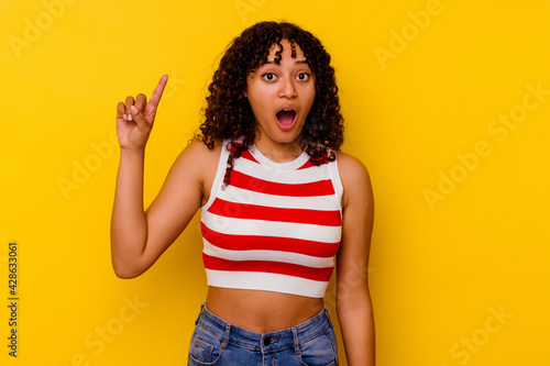 Schilderij op canvas Young mixed race woman isolated on yellow background having some great idea, concept of creativity