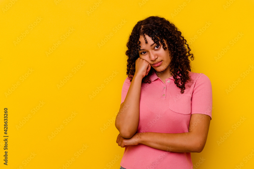Young mixed race woman isolated on yellow background who feels sad and pensive, looking at copy space. Young mixed race woman isolated on yellow background who feels sad and pensive, looking at copy space.