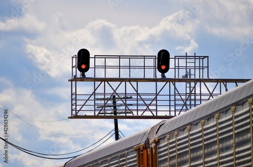 A pair of red signals on a railroad signal tower each protecting one of two tracks prior to a crossing with another railway. The signals provide protection for all trains negotiating the crossing.